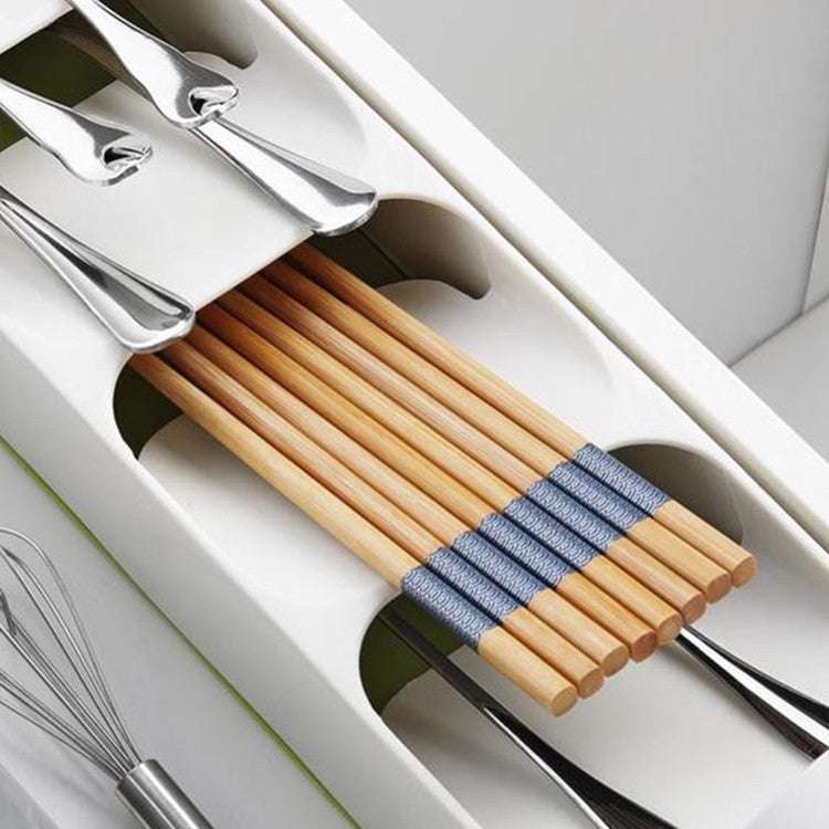 Kitchen drawer cutlery compartment storage box, white and gray, organizing utensils with separate sections.