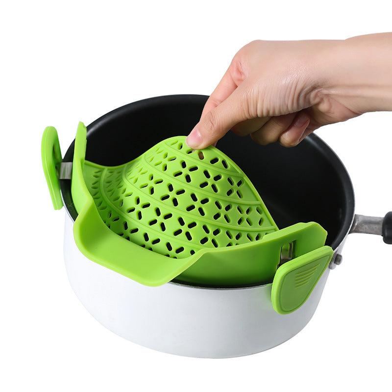 Green silicone pot side drain stopper for modern kitchens.