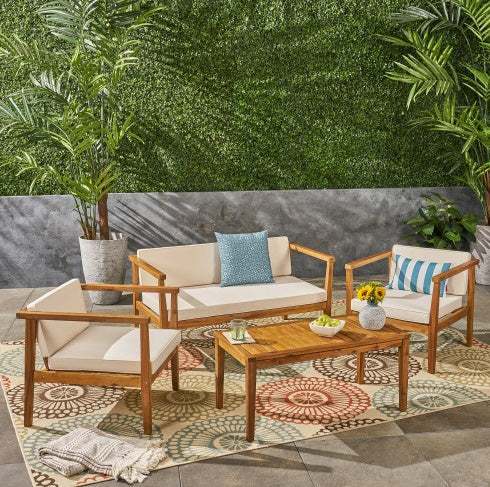 Outdoor 4-seater acacia wood chat set with beige cushions and teak finish, includes loveseat, chairs, and coffee table.