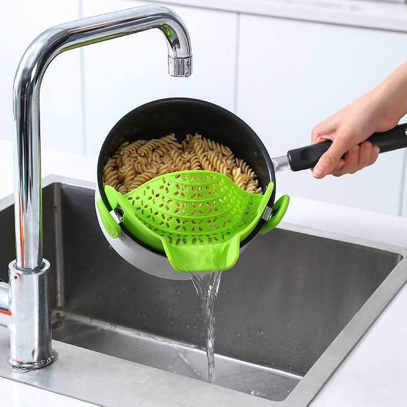 Silicone pot side drain stopper in use, straining pasta over sink.