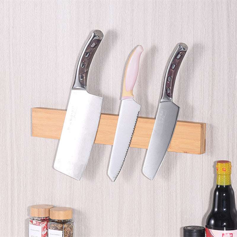 Wall-mounted bamboo magnet knife holder with knives attached, showcasing modern simplicity and magnetic suction.