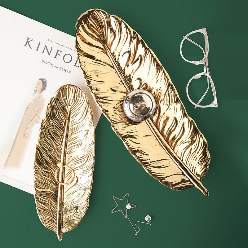 Green ceramic leaf storage tray with smooth glaze finish for home decoration.