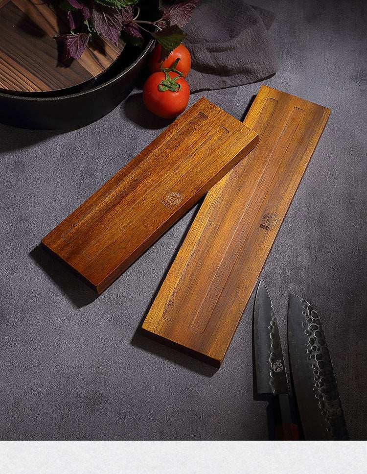 Solid wood wall-mounted magnetic kitchen knife rack on a countertop.
