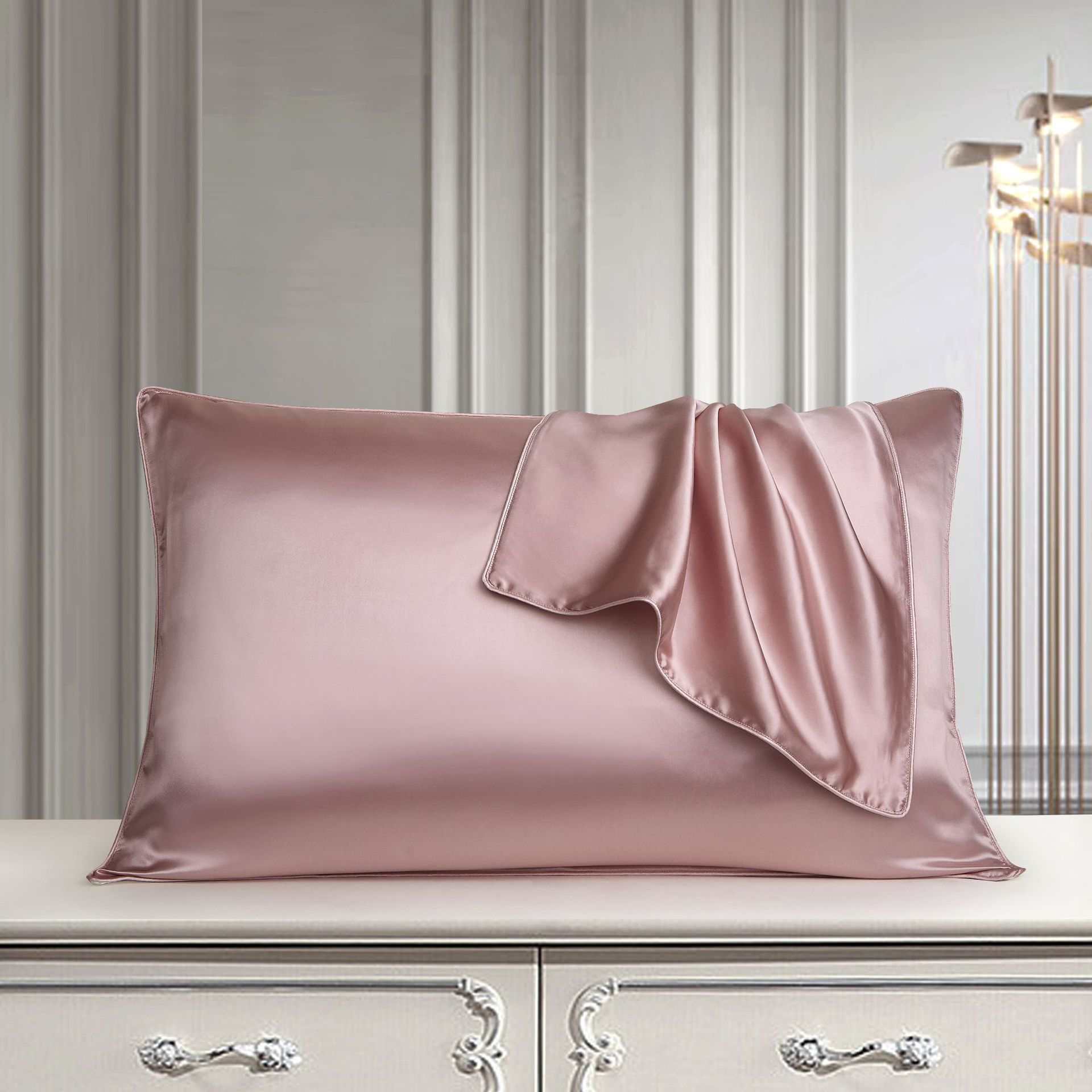 Luxurious pink mulberry silk pillowcase on elegant dresser.