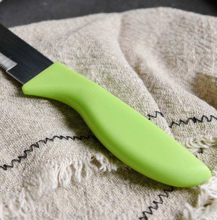 Bakerdream stainless steel serrated bread knife with green PP handle on textured cloth surface.