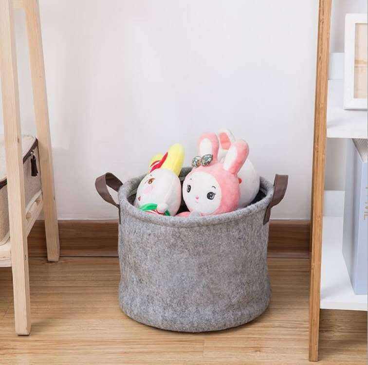 Large round felt fabric sundry storage basket with plush toys inside, featuring simple modern style handles.