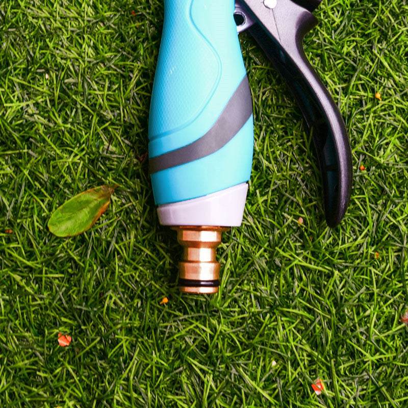 Blue garden sprayer water spray bottle mist gun on grass.