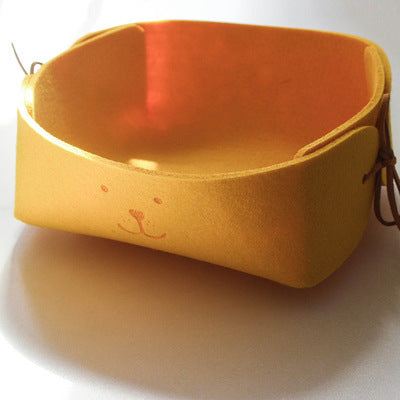 Yellow wool felt sundries basket with smiley face design for desktop storage.