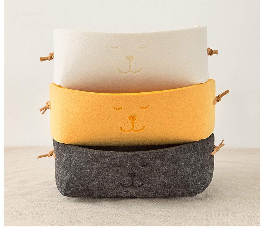 Wool felt storage baskets in beige, yellow, and dark gray with smiley face design, ideal for keys and sundries.