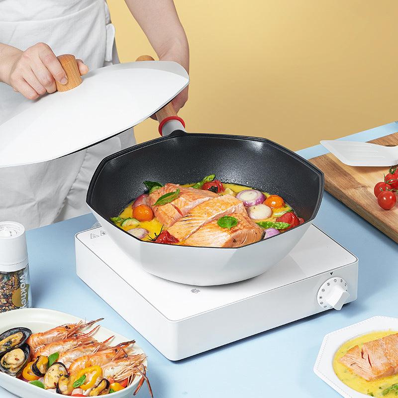 Non-stick frying pan with salmon and vegetables cooking, featuring double pour spouts and a long handle for easy grip.