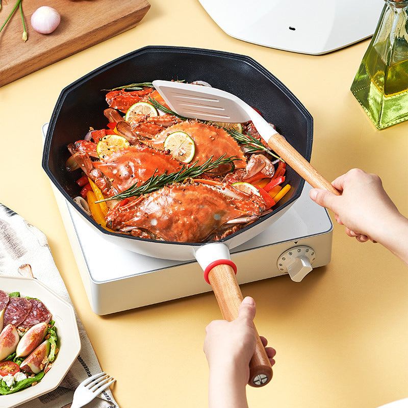 Non-stick frying pan cooking seafood with lemon and rosemary on a stovetop, featuring a long handle and easy-pour spouts.