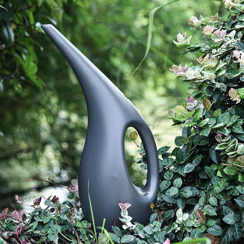 Gardening household watering can with sleek design among greenery.
