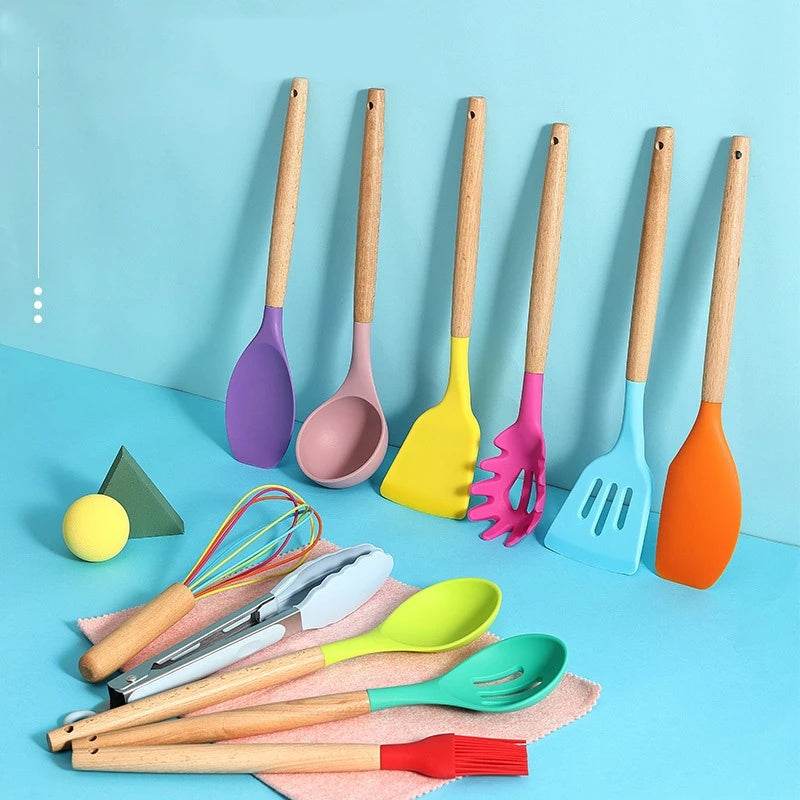 Silicone kitchenware set with wooden handles, including spatulas, spoons, and tongs, displayed on a blue background.