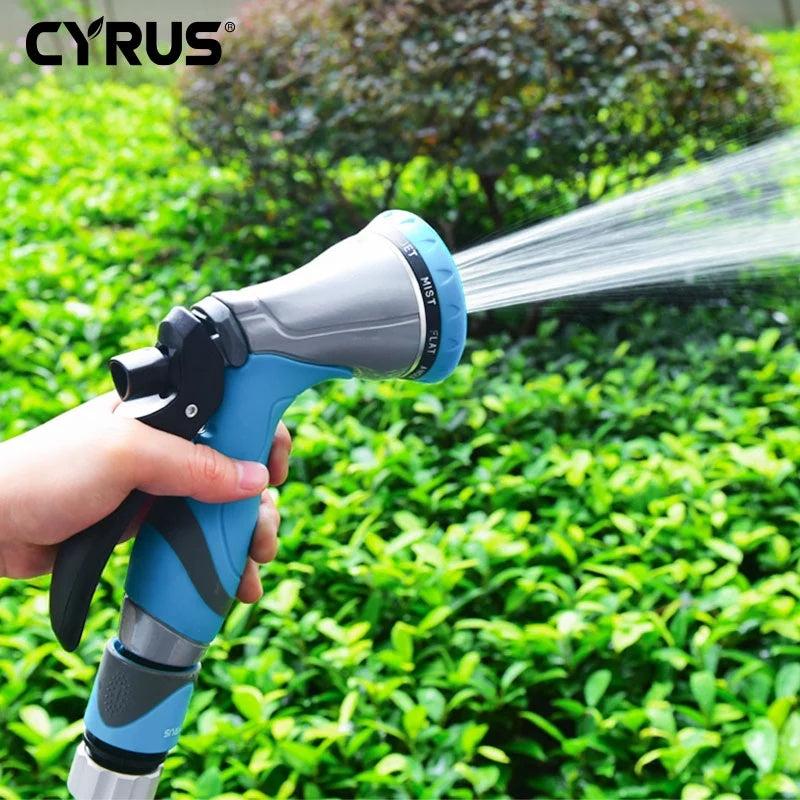 Blue garden sprayer nozzle watering green plants in a garden.