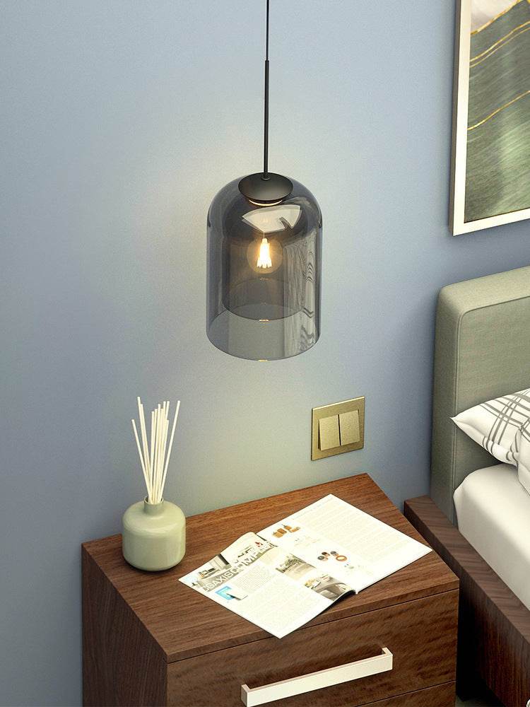 Nordic wall lamp with glass shade, hanging above a modern bedside table in a bedroom setting.