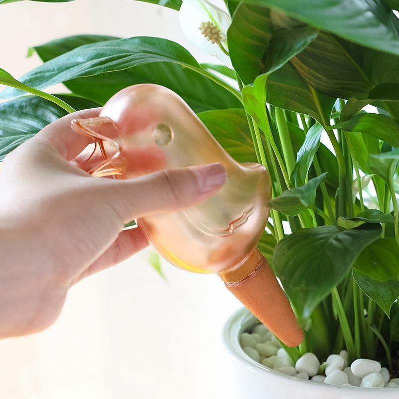 Cute bird-shaped potted plant waterer spike in use, providing easy self-watering for houseplants.