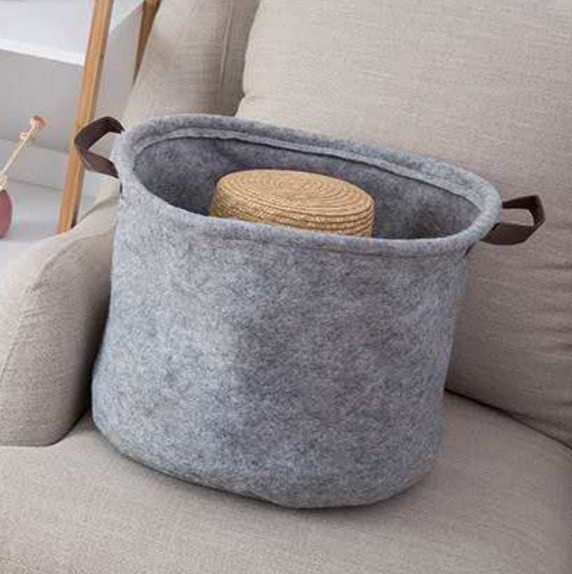 Fabric sundry storage basket made of felt cloth on a sofa.