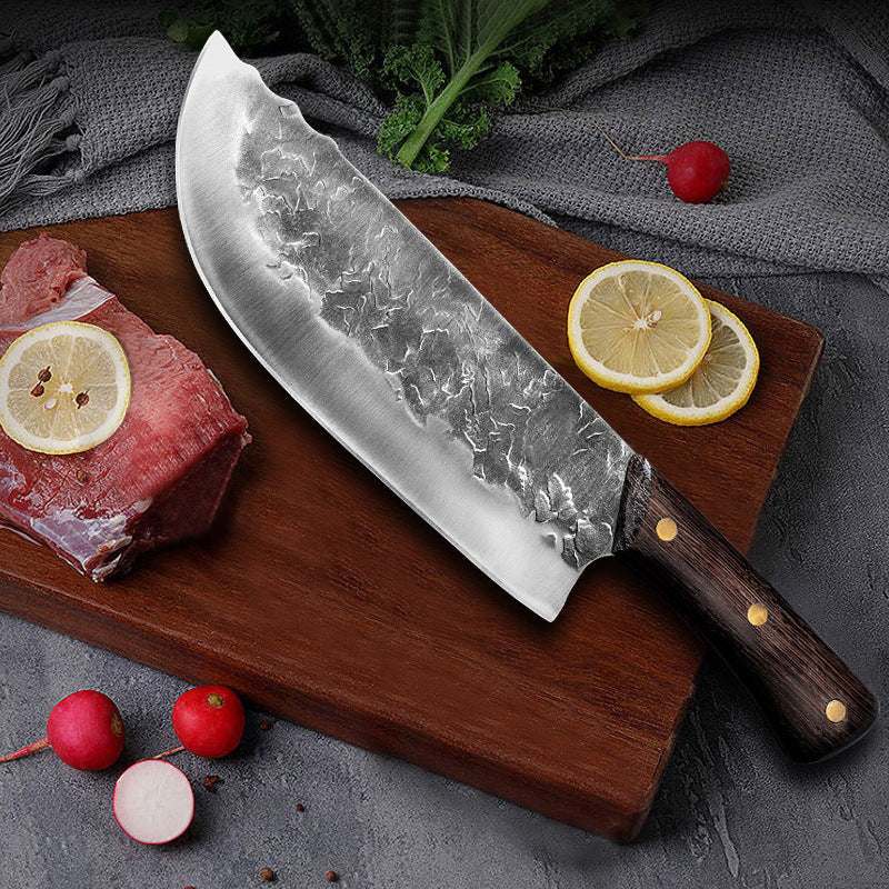 Hand forged stainless steel knife with chicken wing wood handle on cutting board.