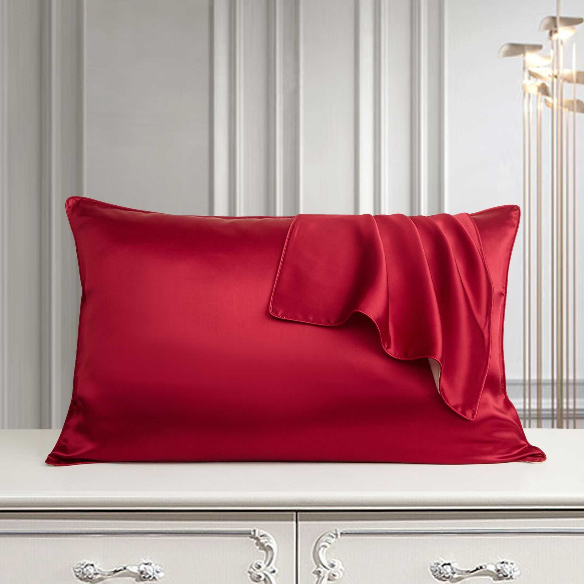 Red silk pillowcase on elegant white dresser in luxurious bedroom setting.