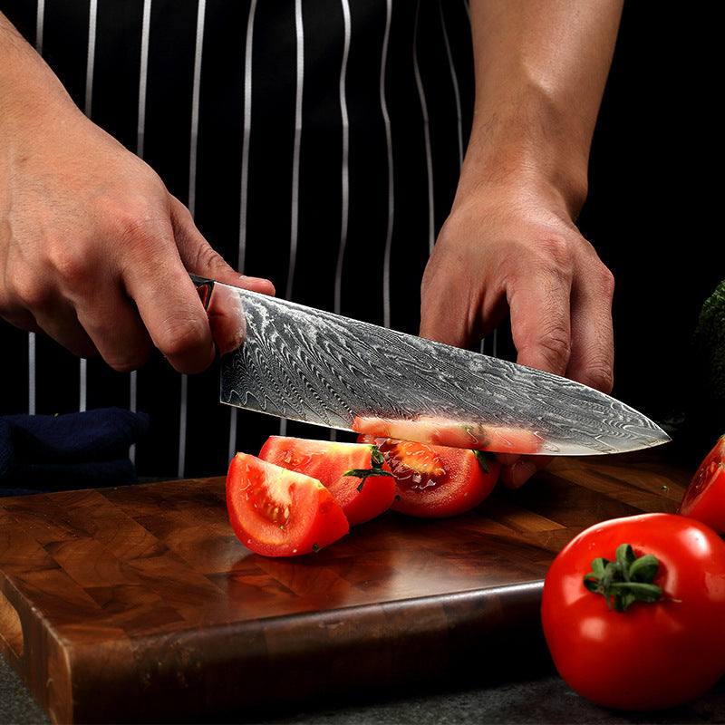 Modern stainless steel kitchen knife slicing tomatoes on a wooden cutting board.