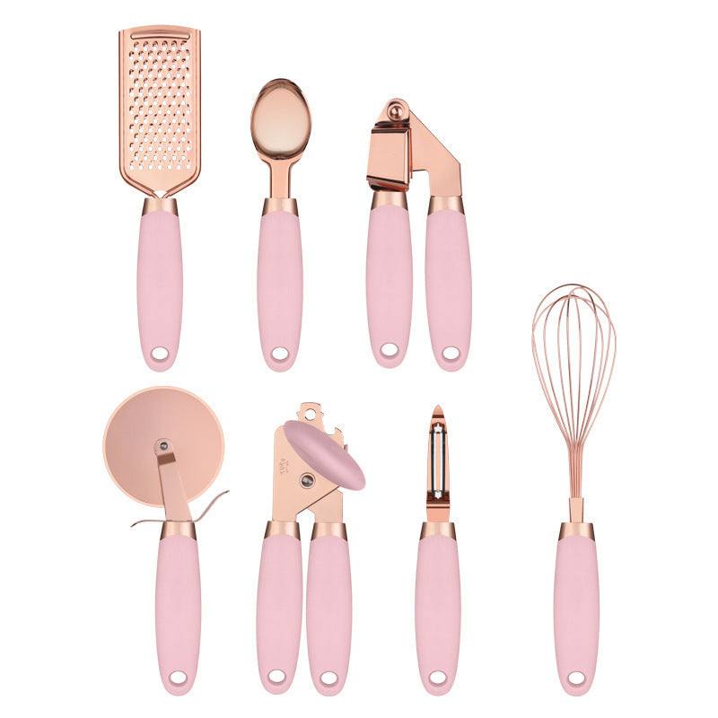 Rose gold kitchen tool set with copper plating and pink handles, featuring seven essential utensils including a peeler.