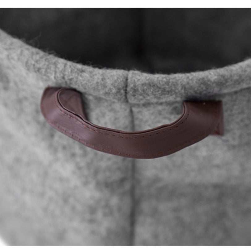 close-up of gray fabric sundry storage basket with brown handle