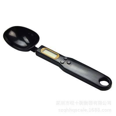 LCD digital kitchen scale with spoon and LCD display for precise measurement of food ingredients.