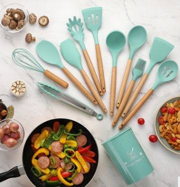 Silicone kitchenware set with wooden handles on a countertop, showcasing various utensils and a bowl of vegetables.