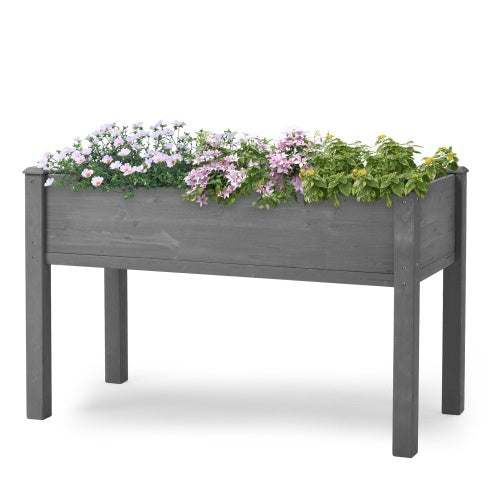 Elevated garden bed with legs, grey solid wood, planted with flowers.