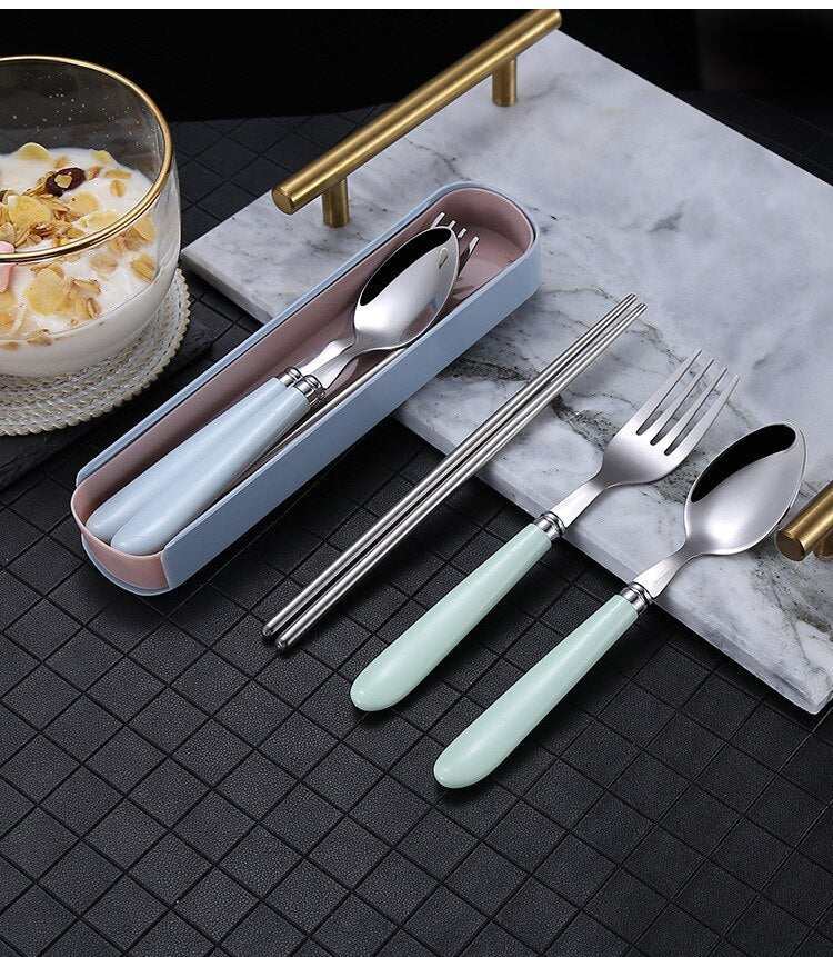 Portable Nordic tableware set with stainless steel fork, spoon, and chopsticks on a marble surface.