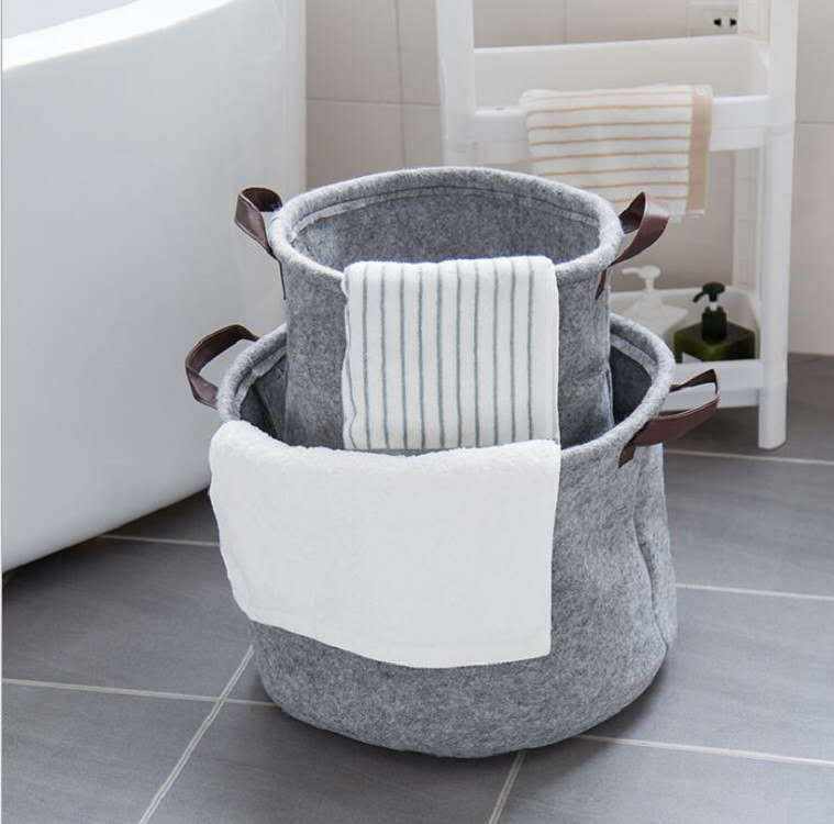 Large round felt fabric sundry storage basket in a modern bathroom setting.