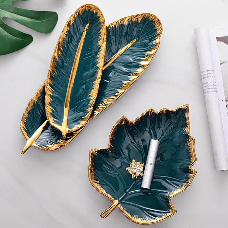 Green ceramic leaf storage tray with smooth glaze finish and golden edges, perfect for home decoration and organizing small items.