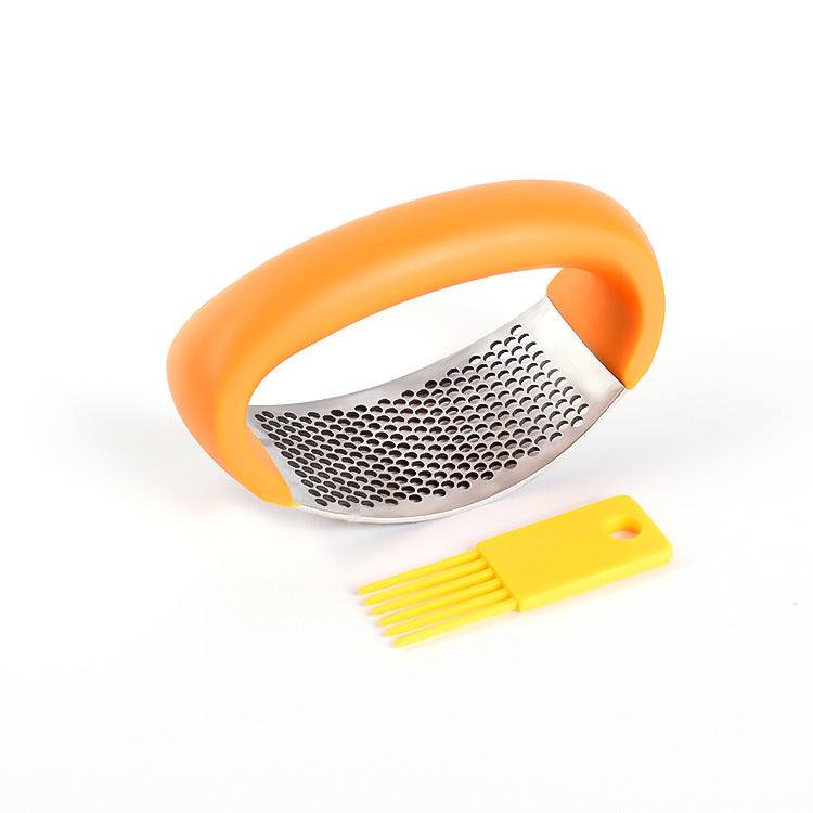 Stainless steel garlic press with ergonomic handle and cleaning tool.