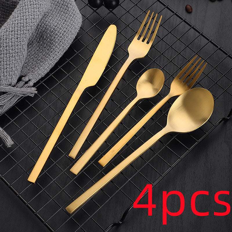Gold stainless steel cutlery set, matte finish, includes knife, fork, spoon set on a grid background.