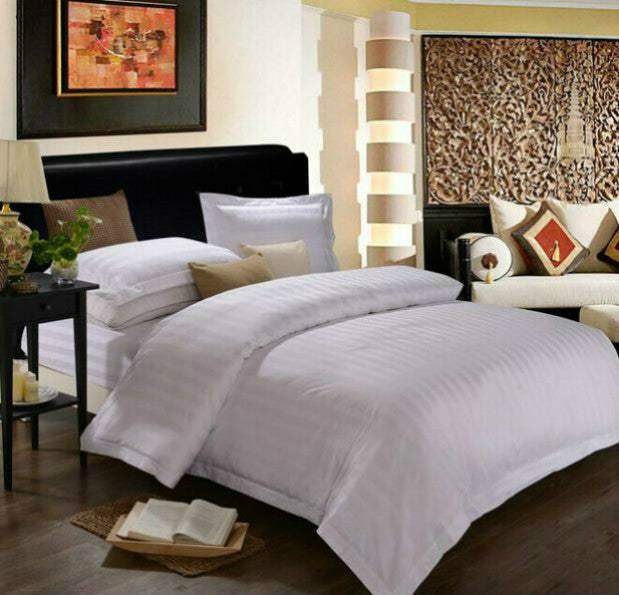 Luxurious four-piece hotel bedding set with polyester cotton fabric on an elegant bed.