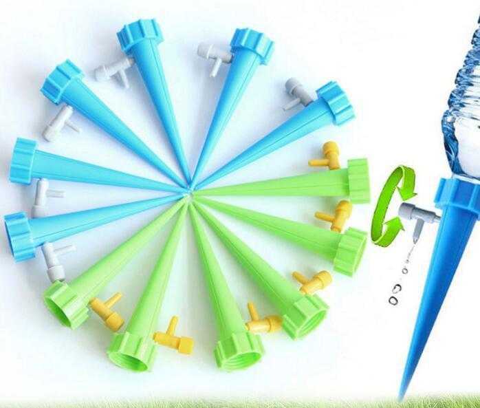 Automatic plant watering spikes in blue and green with bottle attachment for gardening.