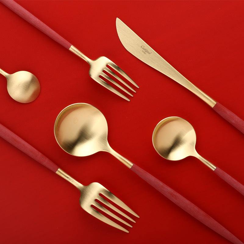 Stainless steel cutlery spoon set with mirror polishing on red background.