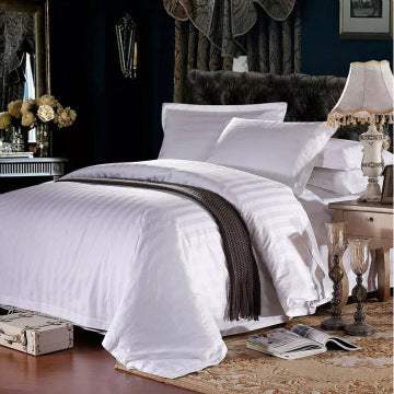 Four-piece hotel bedding set in elegant bedroom display.