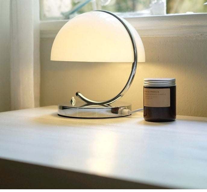 Retro Space Age Table Lamp with glass shade on a bedside table.