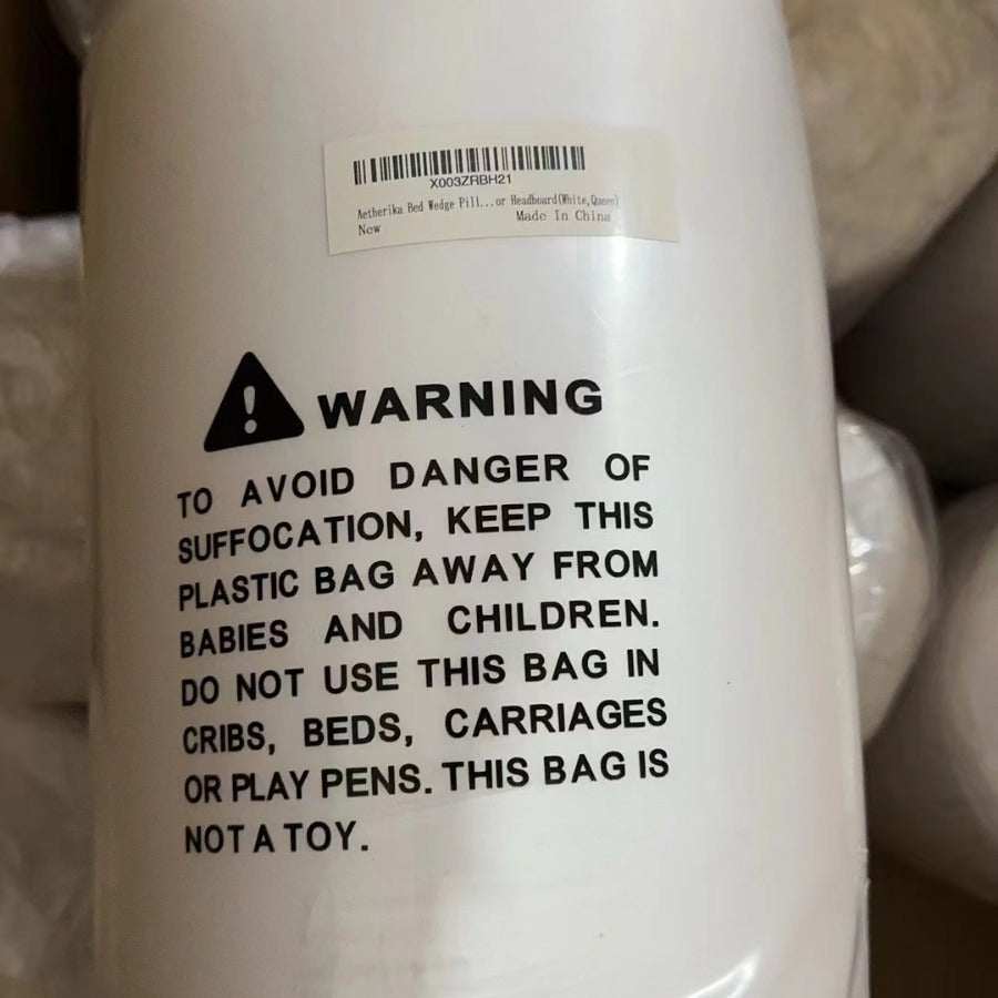 Warning label on white packaging for a long pillow with safety instructions.