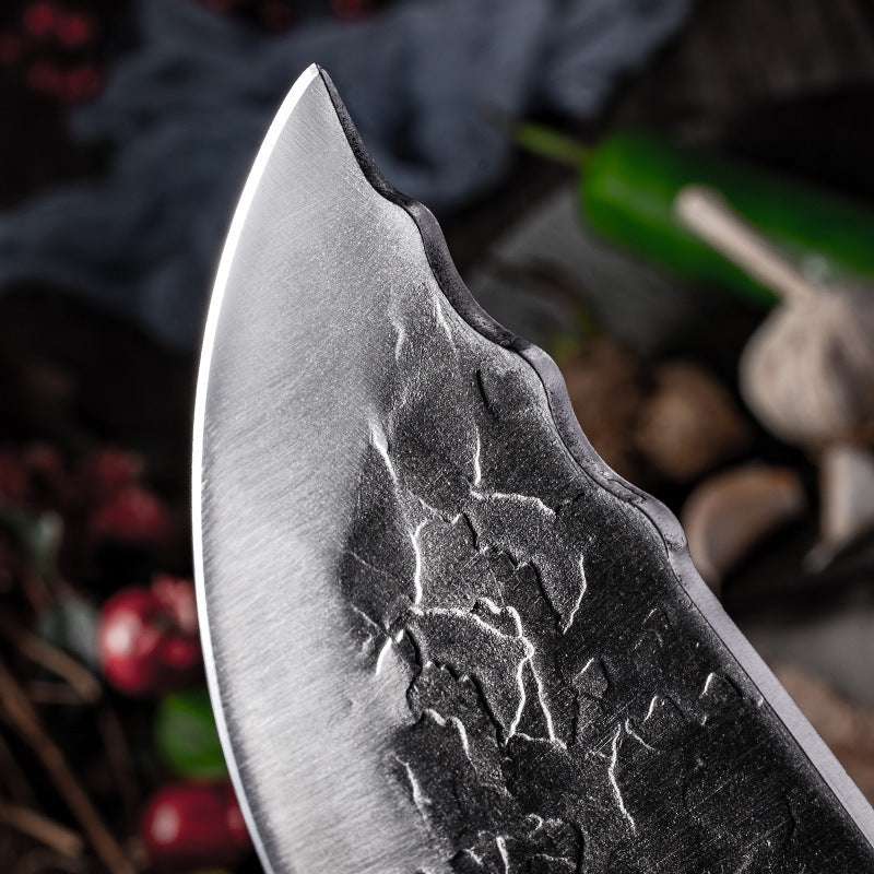 Close-up of hand forged stainless steel knife blade with textured surface, emphasizing craftsmanship and sharpness.