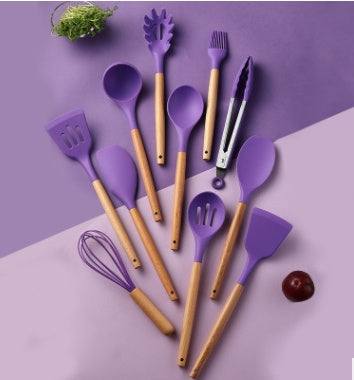 Silicone kitchenware set with wooden handles, featuring purple non-stick utensils for cooking.