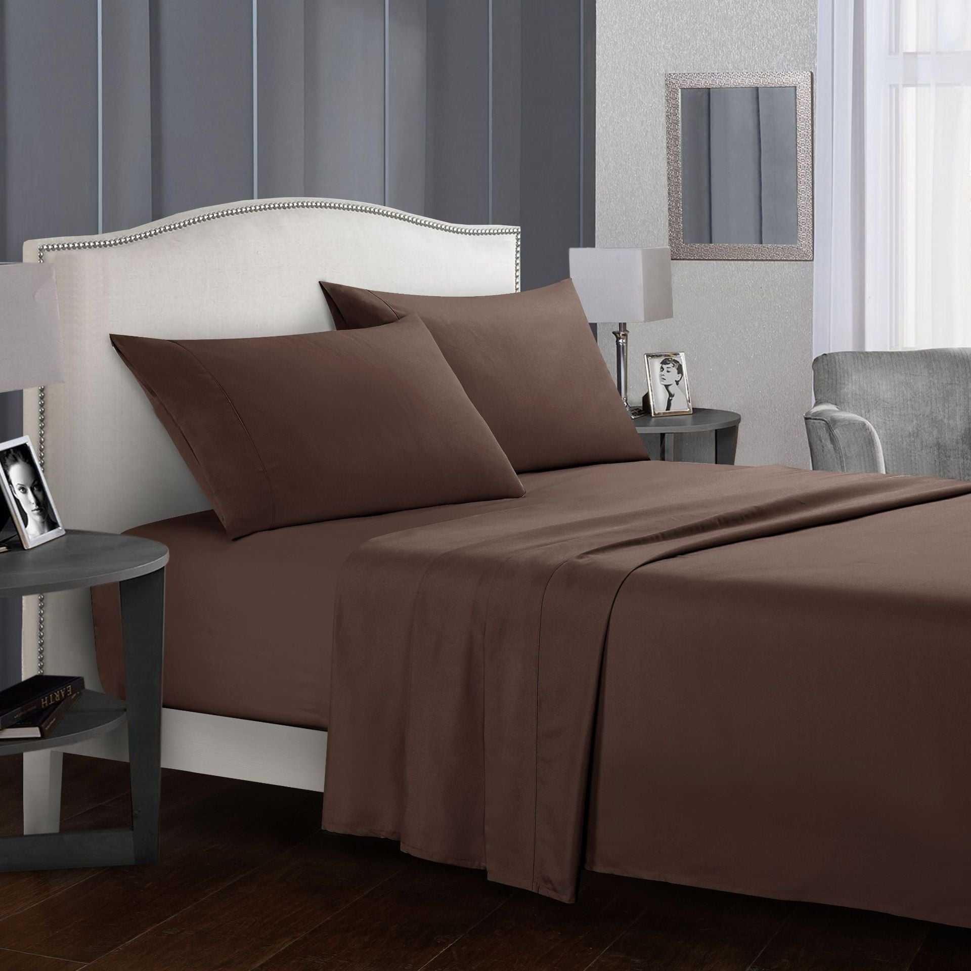 Four-piece bed sheet set on a well-dressed bed with pillows.