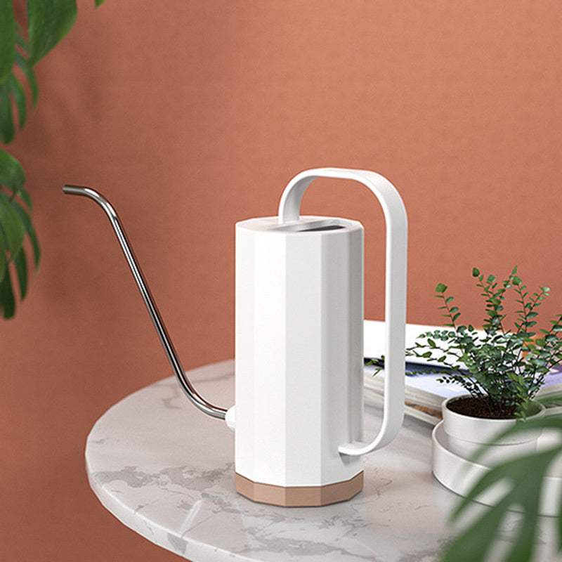 Stylish plant watering can with stainless steel long spout on a table.