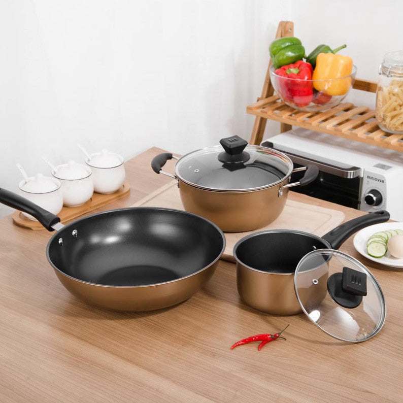Three-piece cast iron cookware set, non-stick pots, includes soup pot, milk pot, and wok on kitchen counter.