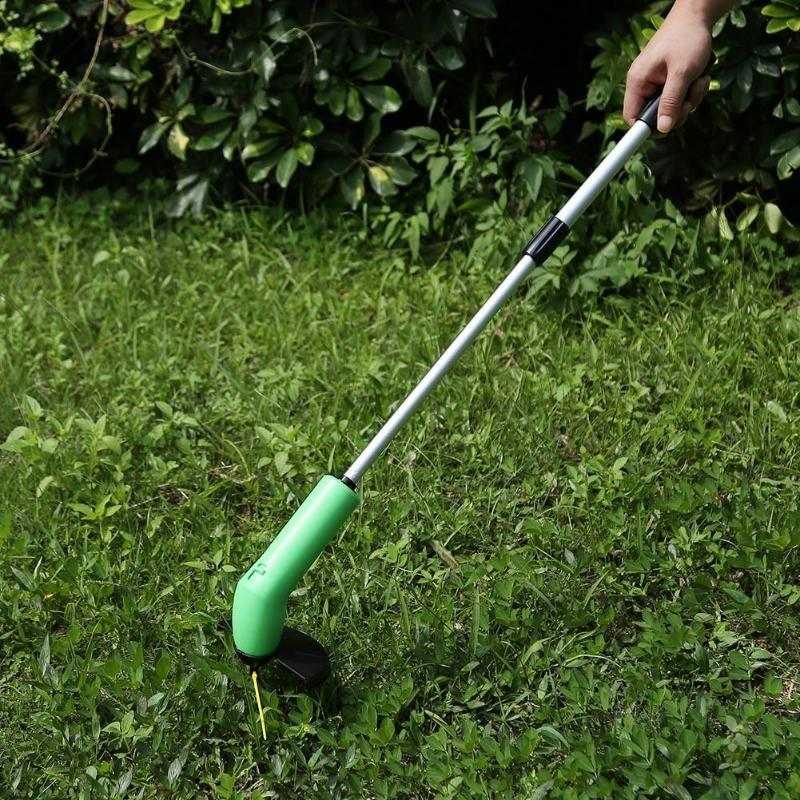 Cordless lawn trimmer being used in garden.