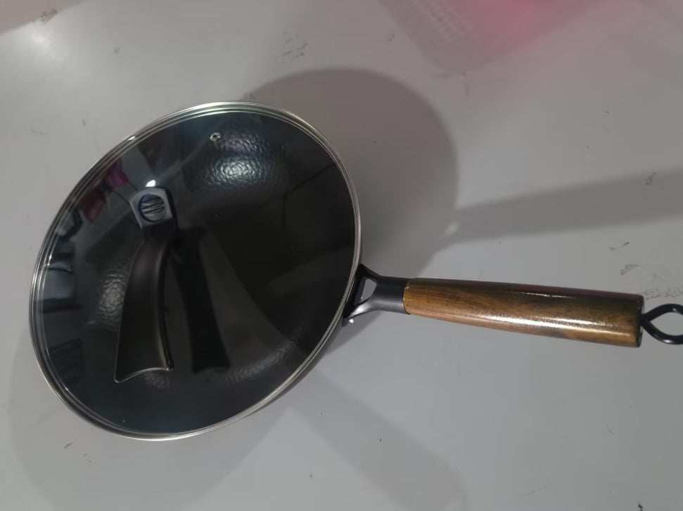 Iron Pan Traditional Iron Wok with wooden handle and lid on a white surface.