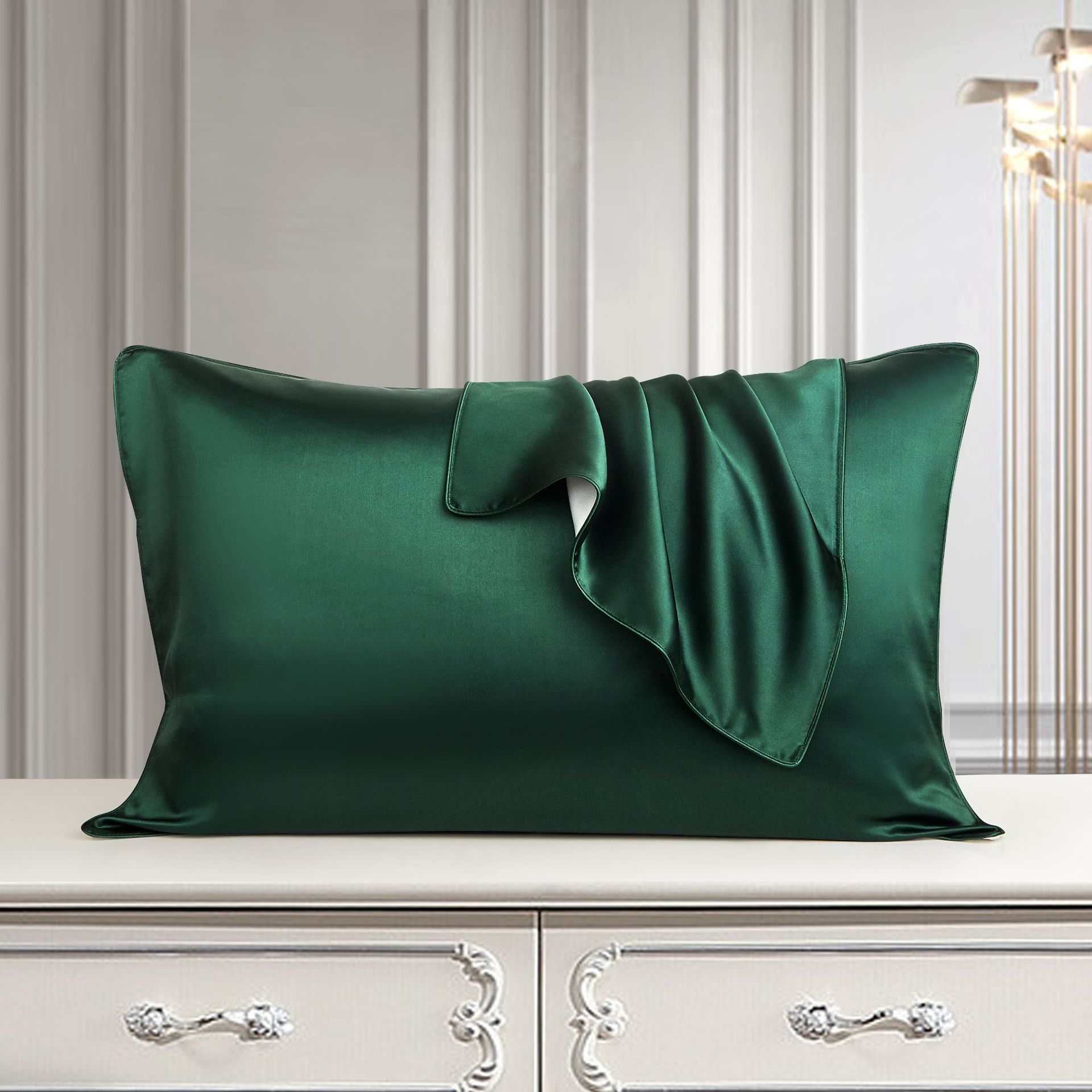 Luxurious green silk pillowcase on elegant dresser in a stylish room.