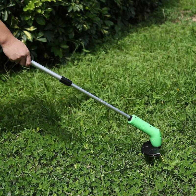 Cordless lawn trimmer with lightweight extension pole in green, used for trimming grass.
