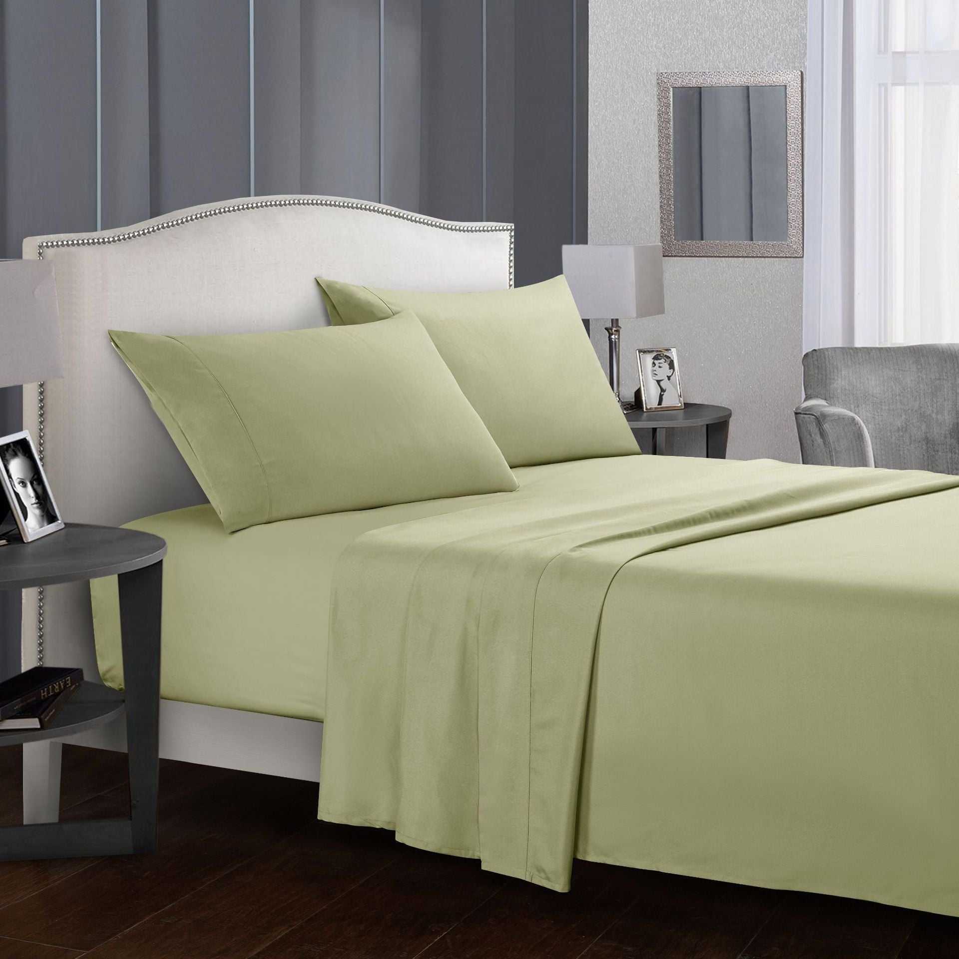 Four-piece bed sheet set in a cozy bedroom setting, showcasing pillows and fitted sheets.